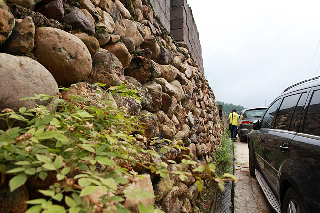 油石鄉(xiāng)梅嶺小學(xué)路口較窄，車隊(duì)只能停在路邊，步行上去